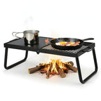 Portable fire pit cooking setup with pots and pan over an open flame on a white background